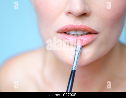 Frau Anwendung Lippenstift mit Make-up Pinsel - Nahaufnahme