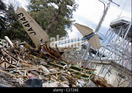 Eine zerstörte Flugzeug liegt unter Trümmern am Flughafen Sendai, Japan, in der Nachmahd der März 2011 Erdbeben + Tsunami. Stockfoto