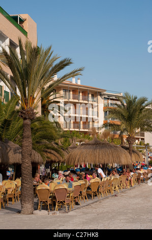 Urlauber genießen, Essen im Freien vor einer Bar / Restaurant in Puerto de Alcudia, Mallorca, Spanien. Stockfoto