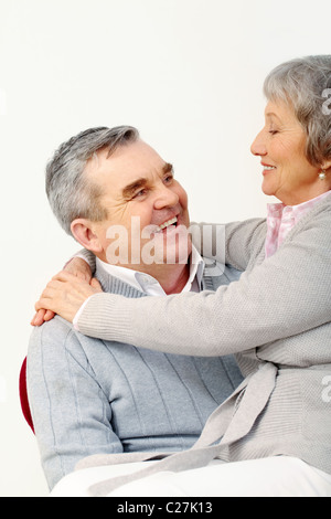 Foto von senior Frau auf des Mannes Knie sitzen und ihn umarmen Stockfoto