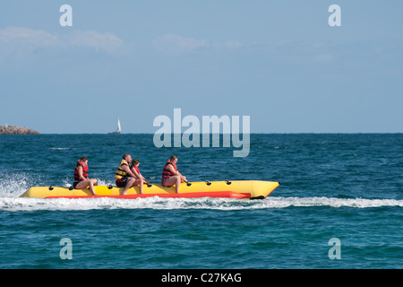 Urlauber genießen eine Fahrt auf einem Bananenboot in dem beliebten Küstenort Puerto de Alcudia, Spanien. Stockfoto