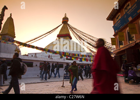 Buddhistischer Mönch zu Fuß bei Sonnenuntergang in der Bodhnath buddhistischen Tempel. Kathmandu, Nepal Stockfoto