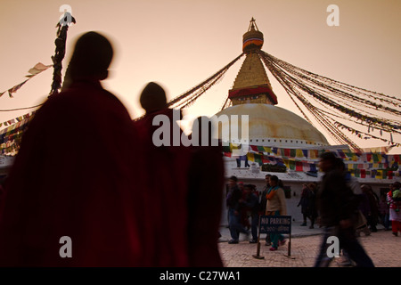 Buddhistische Mönche wandern bei Sonnenuntergang am Bodhnath buddhistischen Tempel. Kathmandu, Nepal Stockfoto