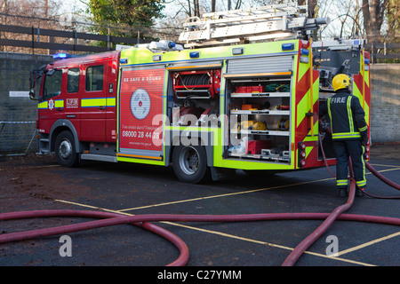 Londoner Feuerwehr, Bahnhof Trainingseinheit. Ein Feuerwehrmann verbindet die Schläuche mit dem Feuerwehrauto. Stockfoto