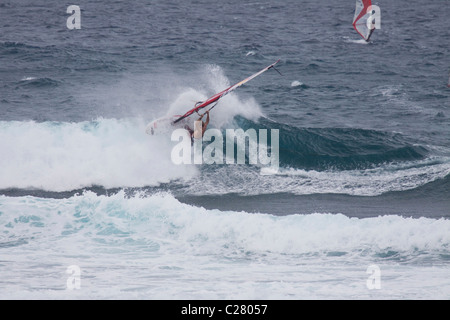 Hängen. Windsurfen am Schnorcheltaucher berühmten Hookipa Beach, gelegen an der windigen North Shore. Stockfoto