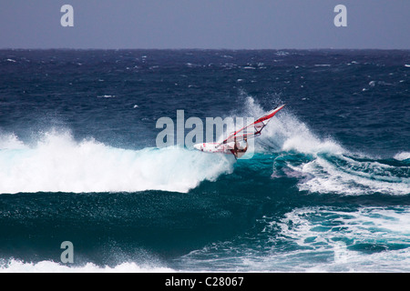 Reiten am Rand. Windsurfen am Schnorcheltaucher berühmten Hookipa Beach, gelegen an der windigen North Shore. Stockfoto