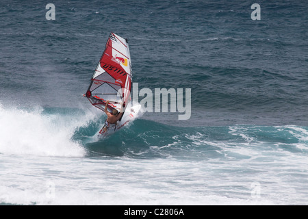 Pflügen durch. Windsurfen am Schnorcheltaucher berühmten Hookipa Beach, gelegen an der windigen North Shore. Stockfoto