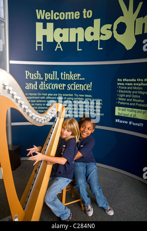 Kind spielt eine elektronische Keniabohne Harfe an der Golf Küste Exploreum Science Center in Mobile, Alabama, USA. Stockfoto