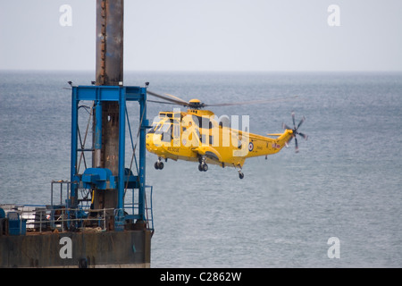 Eine RAF Westland Sea King HAR3/3A schwebt in der Nähe eine Buchse Plattform/Rig während der Durchführung einer Rettungs vor der Küste von Norfolk UK. Stockfoto