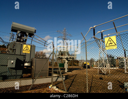 Ein Umspannwerk mit Gefahrenzeichen, angrenzend an einen großen schottischen Windpark. Stockfoto