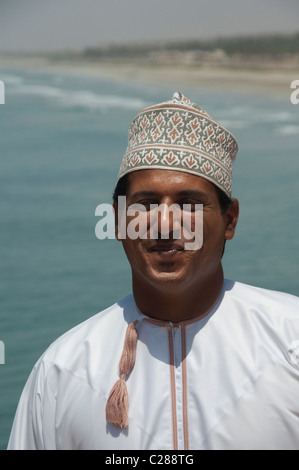 Oman, Dhofar, Salalah. Omanische Mann tragen traditionelle weiße Baumwoll-Kleidung mit Quaste, rief eine Dishdasha. Stockfoto