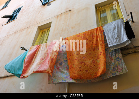 Wäsche aufhängen auf der Wäscheleine vor den Fenstern der Häuser in Ventimiglia, Italien Stockfoto