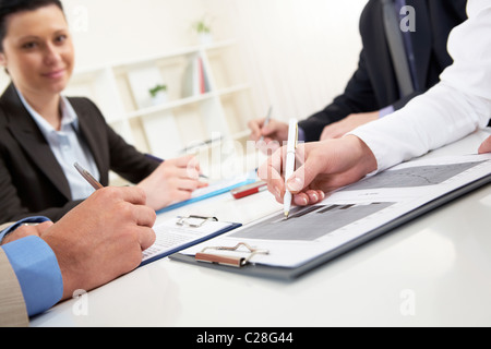 Nahaufnahme der Unternehmer mit der hand über Dokument im Arbeitsumfeld Stockfoto