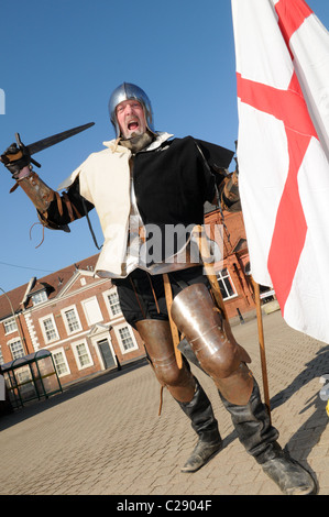 Mann verkleidet als ein englischer Ritter schwingt ein Schwert und große Flagge von St. George nach Englands St.-Georgs-Tag in Dudley feiern Stockfoto