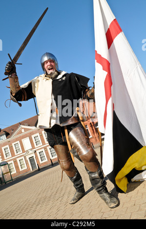 Mann verkleidet als ein englischer Ritter schwingt ein Schwert und große Flagge von St. George nach Englands St.-Georgs-Tag in Dudley feiern Stockfoto