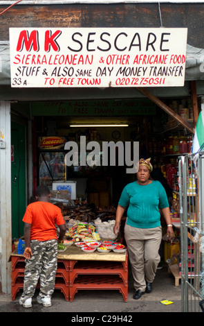 Frau Ladenbesitzerin und Kind im afrikanischen Lebensmittelgeschäft MK Sescare Sierra Leone in Ridley Road Market, Dalston East London England Großbritannien KATHY DEWITT Stockfoto