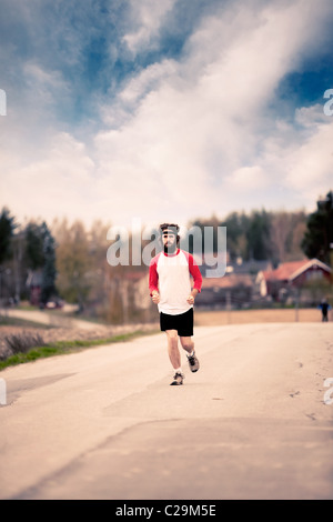 Ein Läufer mit langen Haaren und Bart Joggen auf dem Lande - Retro-Style-image Stockfoto