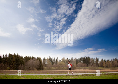 Ein Läufer mit langen Haaren und Bart Joggen im Land Stockfoto