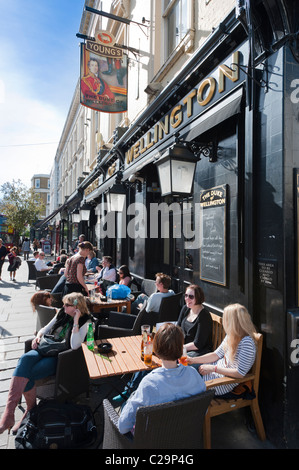 Menschen verbringen und einige früh Sommer Sonne außerhalb der Herzog von Wellington Gastwirtschaft (Kneipe) in Notting Hill, London, England, UK. Stockfoto