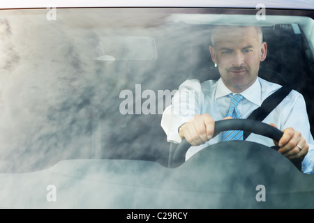 erhöhte Ansicht des kaukasischen ausgereifte Business-Mann mit Händen am Lenkrad, wegschauen. Stockfoto