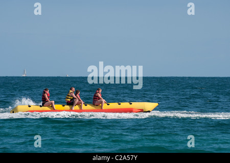 Urlauber genießen eine Fahrt auf einem Bananenboot in dem beliebten Küstenort Puerto de Alcudia, Spanien. Stockfoto