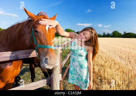 Pferd und blonde Mädchen im Fahrerlager am Sommer Stockfoto