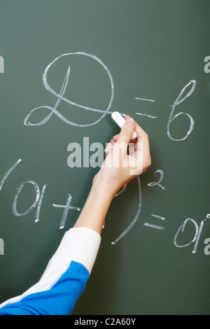 Hand des Schülers während Algebra Lektion Formel an Tafel schreiben Stockfoto