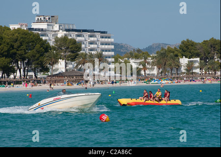 Urlauber genießen eine Fahrt auf einem Bananenboot in dem beliebten Küstenort Puerto de Alcudia, Spanien. Stockfoto