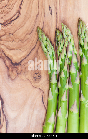 Spargelstangen auf einem Oliven Holz Brett Stockfoto