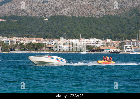 Urlauber genießen eine Fahrt auf einem Bananenboot in dem beliebten Küstenort Puerto de Alcudia, Spanien. Stockfoto