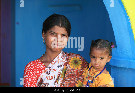 Indische Mutter mit Kind auf blauen und gelben Tür Andhra Pradesh in Indien Stockfoto