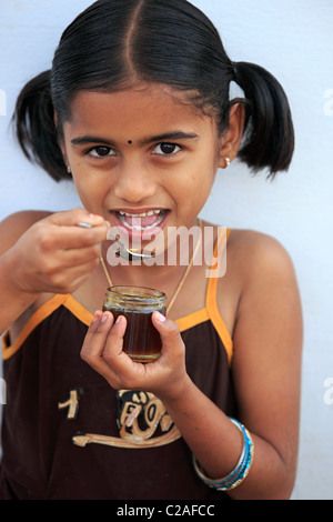 Indische Mädchen essen Honig Andhra Pradesh in Indien Stockfoto