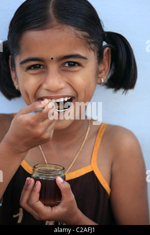 Indische Mädchen essen Honig Andhra Pradesh in Indien Stockfoto