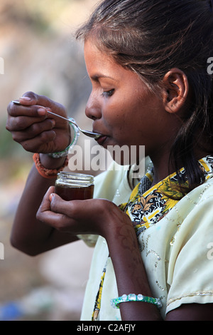 Indische Mädchen essen Honig Andhra Pradesh in Indien Stockfoto