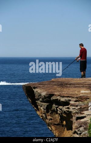 Mann Angeln vom Klippe in Sydney Stockfoto