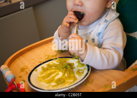 Babymädchen kauen auf Löffel Stockfoto