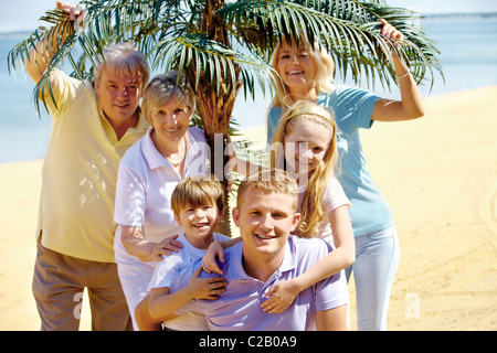 Porträt der glücklichen senior und junge Paare, Blick in die Kamera während der Ferien mit Grünpflanze im Hintergrund Stockfoto