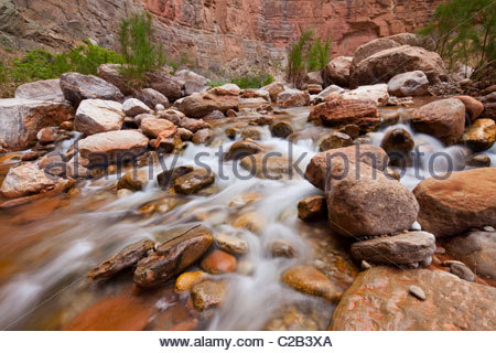 Ein schneller bewegender Bach fließt über die Wüste Felsen. Stockfoto