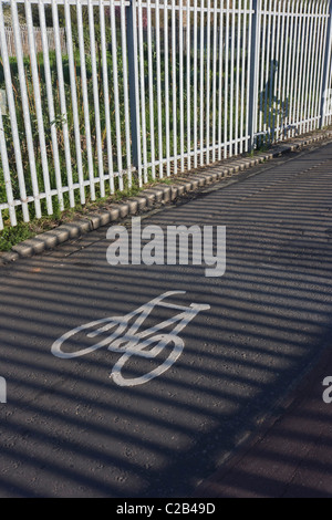 Ein pendeln Radfahrer fährt neben sonnigen Geländer auf eine Rennstreckenareal in Kennington, Südlondon. Stockfoto