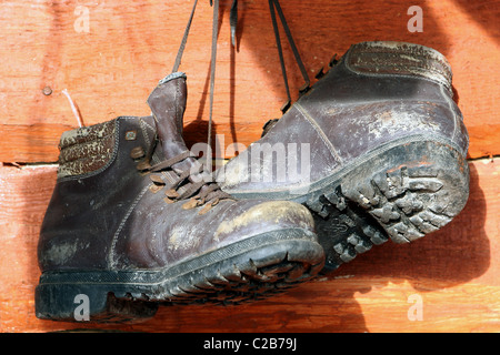 Eine abgenutzte Wandern Paar Stiefel an der Wand hängen. Stockfoto