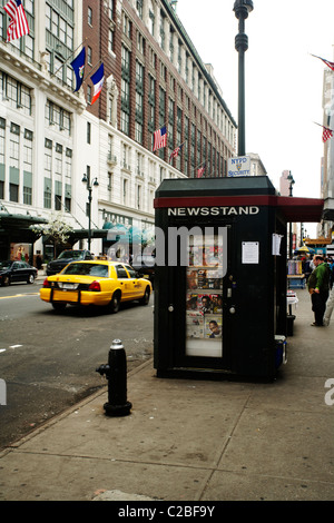 Straßenverkäufer Kiosk mit einer gelben Taxi fahren in New York City Stockfoto