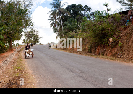 Ein Mann zu Fuß bergab mit einem Push Cart von Wellpappe Zinn Bedachungen. Kisarawe Dorf Daressalam / Tansania. Stockfoto