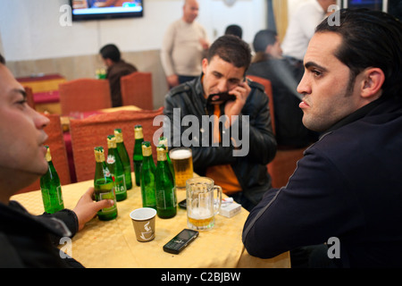 Junge Kunden trinken Bier, Kaffee und rauchen Zigaretten in einem Hotel bar mit Alkoholausschank in Sfax, Tunesien. Stockfoto