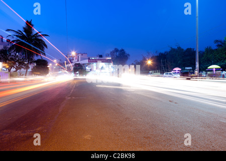 Lichtspuren vom Verkehr auf einer belebten Straße in der Abenddämmerung in Sholapur Indien Stockfoto