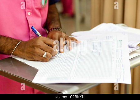 Eine Krankenschwester schreibt sich Patienten Noten in eine Intensive Care Unit (ICU) in Indien Yashodhara Krankenhaus Sholapur Stockfoto