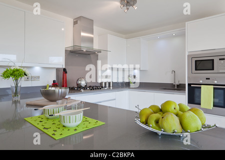 Neu Anbauküche moderne mit eingebauten Geräte, Geschirr und Obstkorb Stockfoto