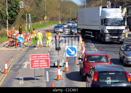 Blick von oben Blick nach unten gut sichtbare Arbeiter an Straßenbauarbeiten an einer temporären Dreiwege-Ampelkontrollwarteschlange von Fahrzeugen Cambridge England UK Stockfoto