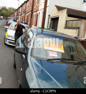 Polizei beschlagnahmt eine nicht versicherte Auto auf einer Straße in Nottingham, England, Vereinigtes Königreich Stockfoto