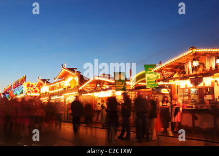 Menschen schlendern zwischen den Verkaufsständen, Snacks auf dem Oktoberfest Kirmes auf den Theresienwiesen in München. Stockfoto