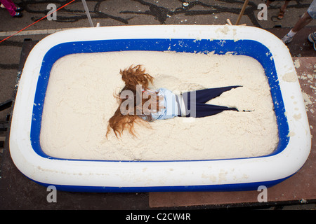 Ein Teilnehmer in der Grütze Roll schwelgt in einem Pool von Grütze während des jährlichen Welt-Grütze-Festival in St. George, SC Stockfoto